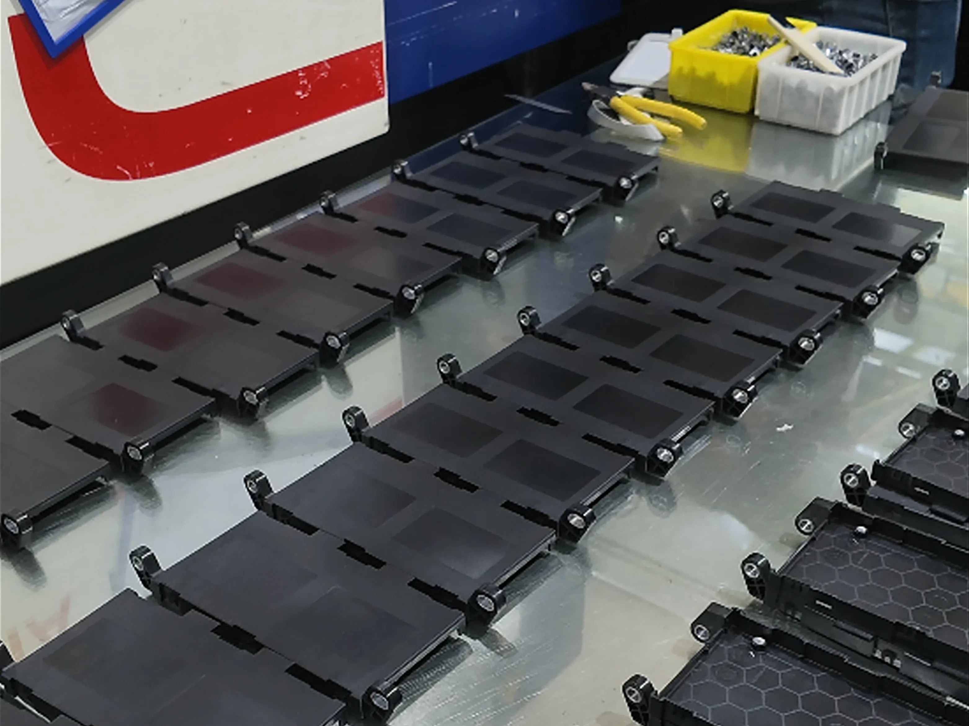 Black insert-molded plastic components arranged for production inspection