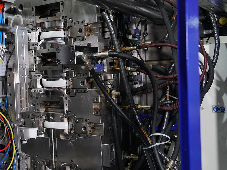 Precision injection mold components with hydraulic hoses in industrial machinery