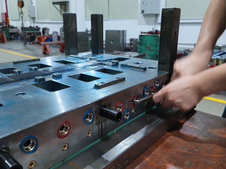 Plastic mold production team inspecting injection mold venting and air control during mold maintenance