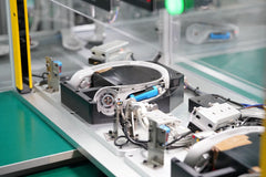 A wearable electronic prototype undergoing rigorous functional testing and validation within a custom automated assembly fixture during the pilot run and PVT phase.