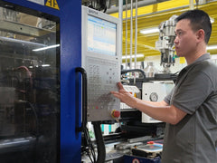 Operator adjusting the control panel of an injection molding machine