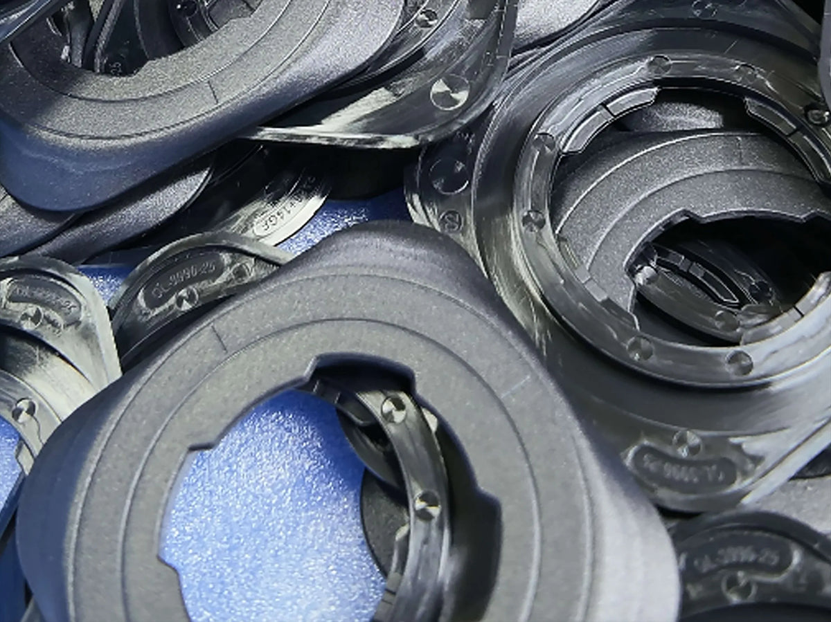 Close-up of stacked black rings with toothed inner openings on a blue surface.