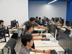Engineers in a design office review computer screens together while working on mold simulation and manufacturing analysis tasks for production.