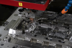 EDM electrode machines a polished complex mold cavity with detailed ribs, slots, and reflective metal surfaces.