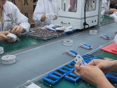 Workers assembling electrical components on a manufacturing line